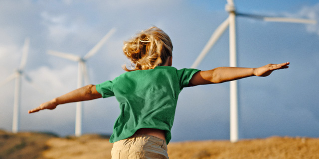 Child running in landscape of wildmills